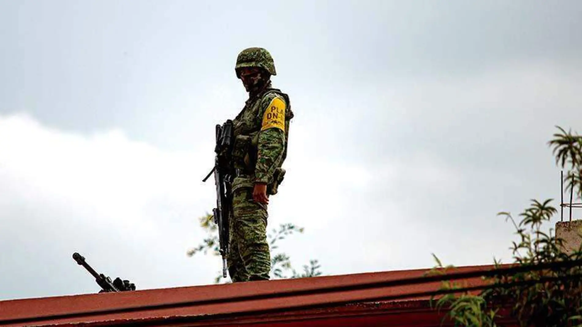 Militar mantiene vigilancia sobre una barda